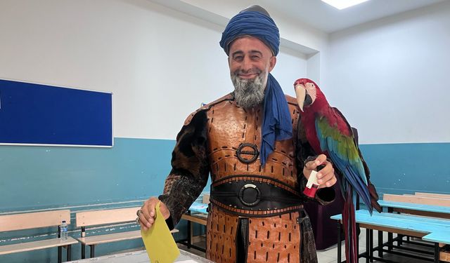 Oy kullanmaya papağanı ve kostümüyle geldi